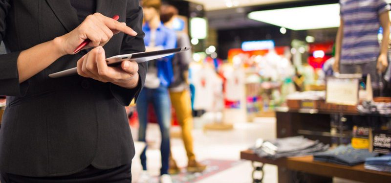 Woman retail associate using tablet in store